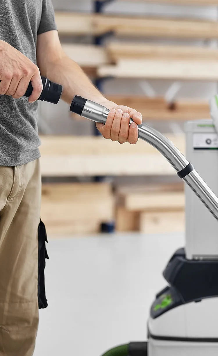 Mann bringt Saugschlauch an Industriesauger an