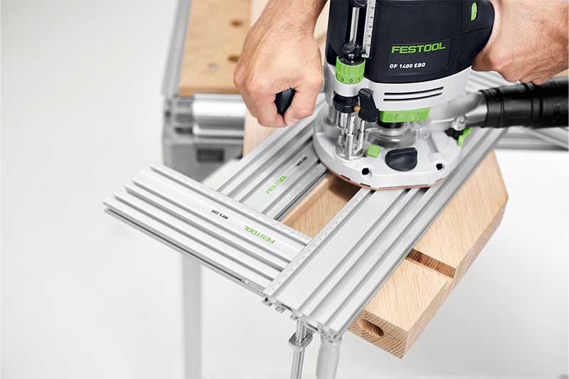 Handwerker fräst Werkstück mithilfe mehrerer Frässchablonen