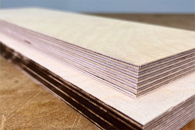 Zwei geschnittene Bretter übereinander, wobei eines eine verbrannte Kante aufweist