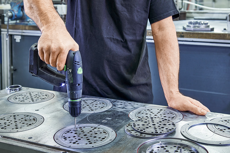 Handwerker bearbeitet Schleifmittel-Platten aus Metall