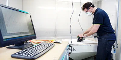 Ein Akkuschleifer von Festool wird in der Akustikkammer getestet.