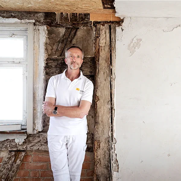 Manfred Schuler, Malermeister und Restaurator vor der Wand des zu restaurierenden Fachwerkhauses