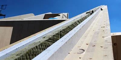 Die Wände eines Massivholzhauses aus Fichtenholz und verschiedenen Dämmstoffen.