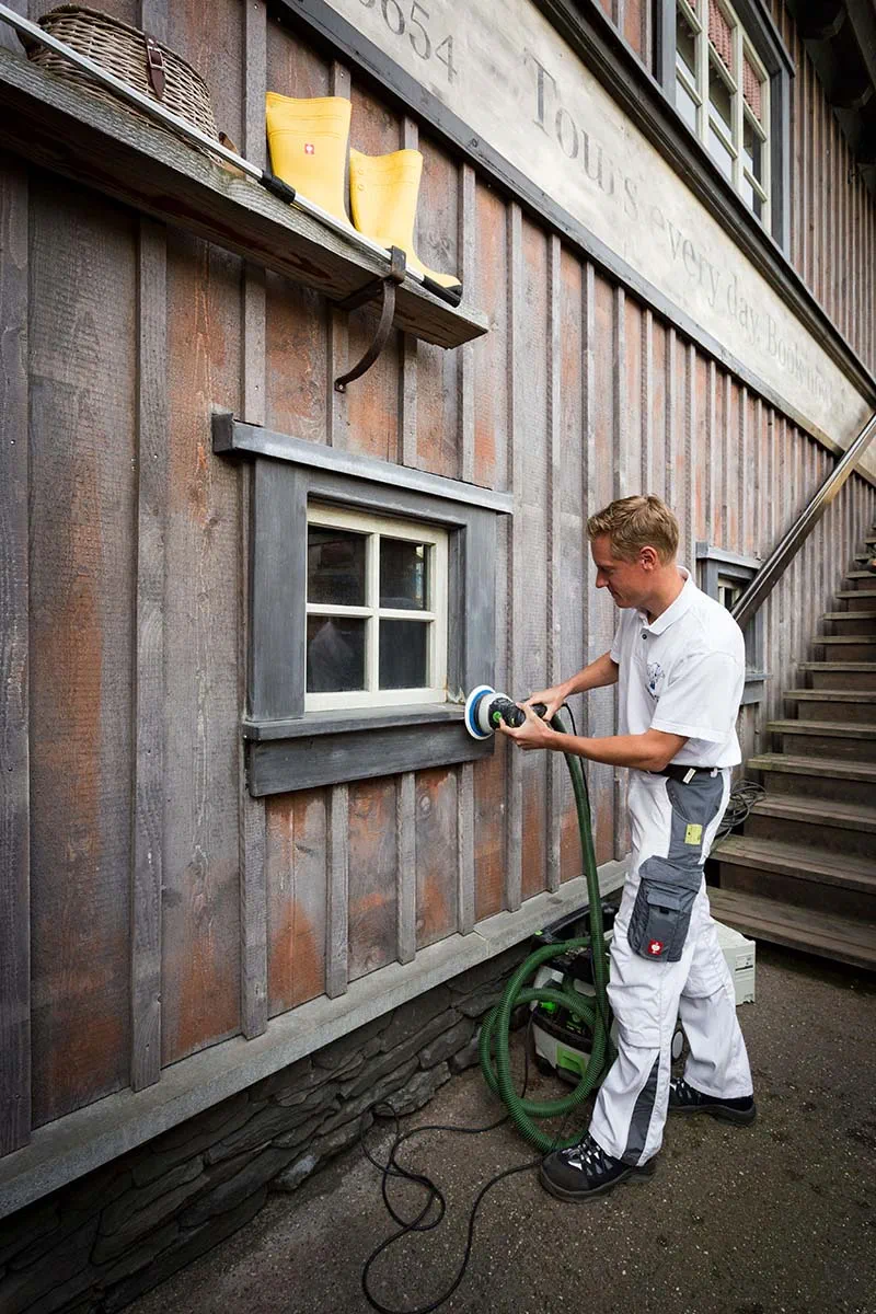 Ein Maler des Europa-Parks bearbeitet die Oberfläche mit einem Schleifer von Festool.