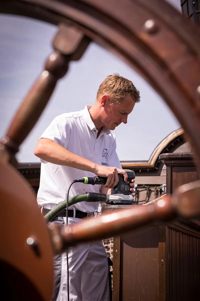 Ein Maler des Europa-Parks bearbeitet die Oberfläche mit einem Schleifer von Festool.
