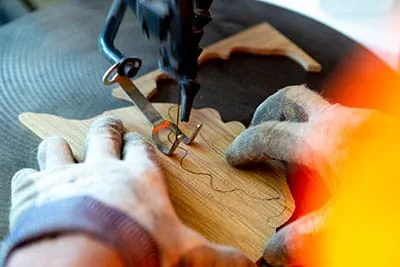 Der Parkettleger schneidet die Verzierungen zu