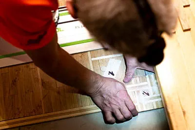 Der Parkettleger bereitet die einzelnen Parkettstücke vor