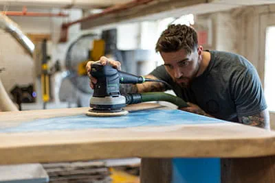 Abschleifen der Oberfläche eines "River Tables" mit dem Festool Exzenterschleifer