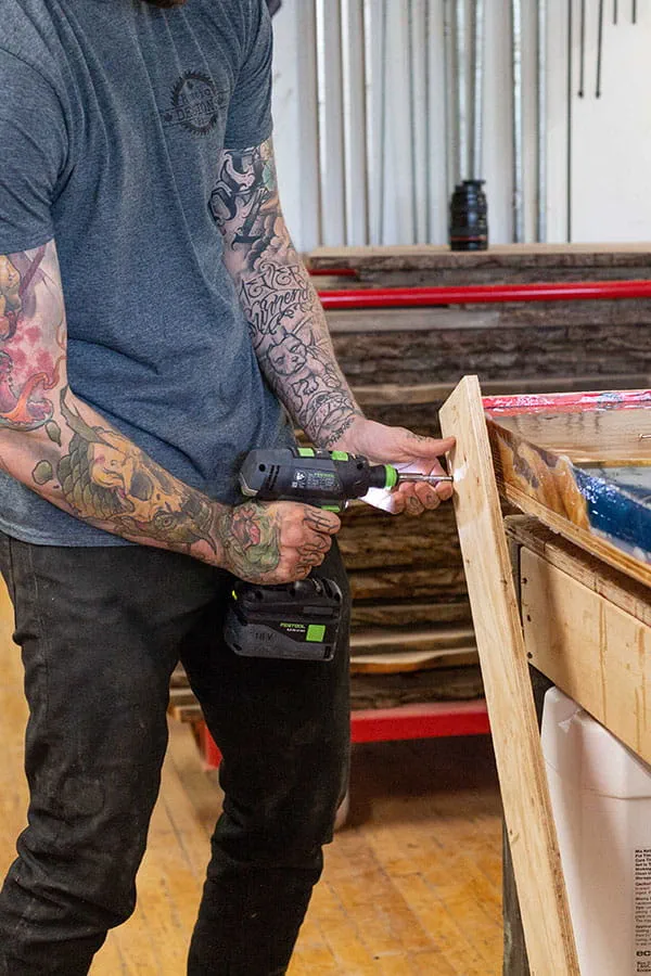 Der Rahmen wird vom fertigen "River Table" mit dem Festool Akku-Bohrschrauber entfernt