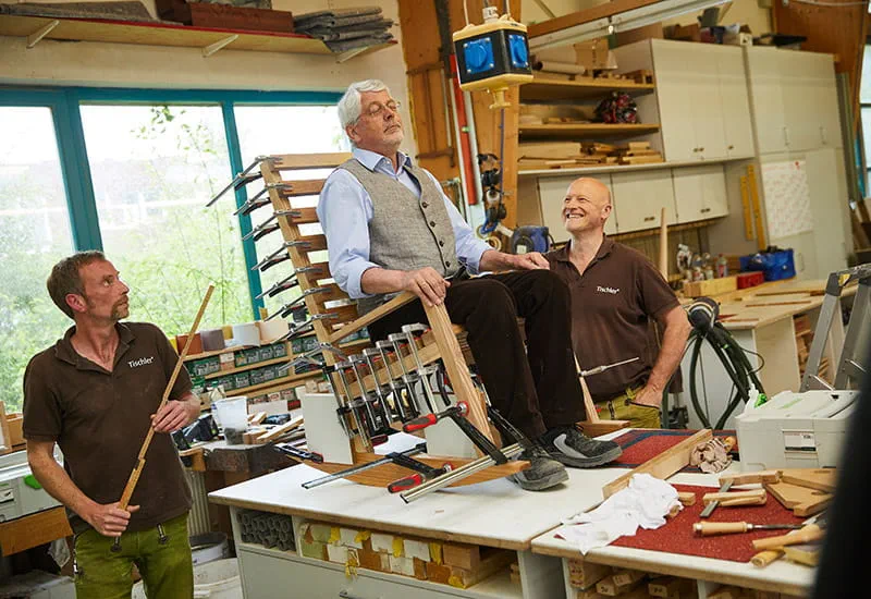 Der Kunde Möllmann testet seinen selbstgebauten Schaukelstuhl aus Eschenholz.