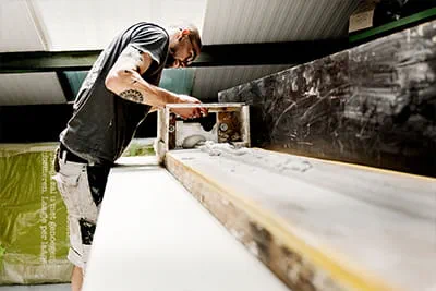 Mit einfachen Hilfsmitteln und nach alter Tradition fertigt Sam Kerckaert im Obergeschoss der Werkshalle eine Stuckleiste an.