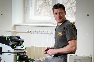 Der Parkettlegermeister umgeben von sorgsam gestapelten Systainern, mit denen er die Baustelle in Ordnung hält.